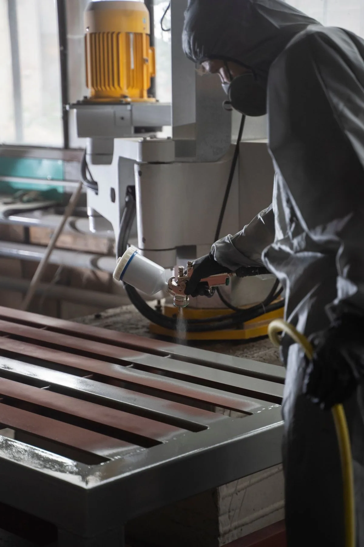 Coater spraying a steel gate frame